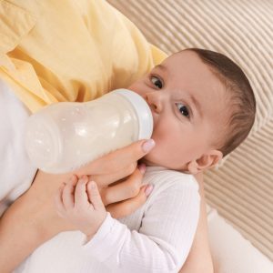 Mama hranind un bebelus cu biberonul