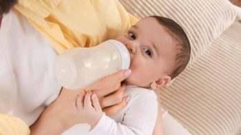 Mama hranind un bebelus cu biberonul