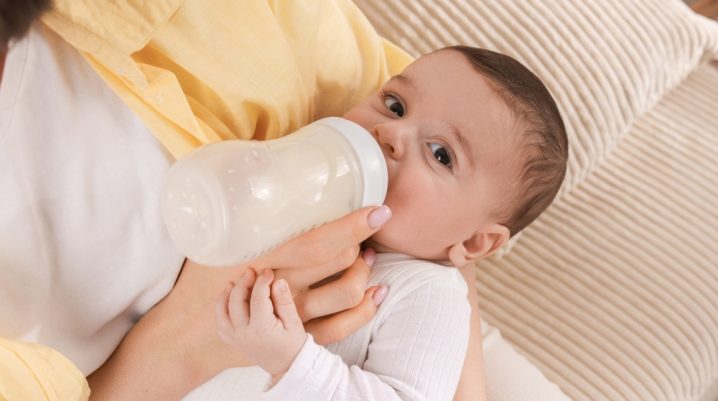 Mama hranind un bebelus cu biberonul